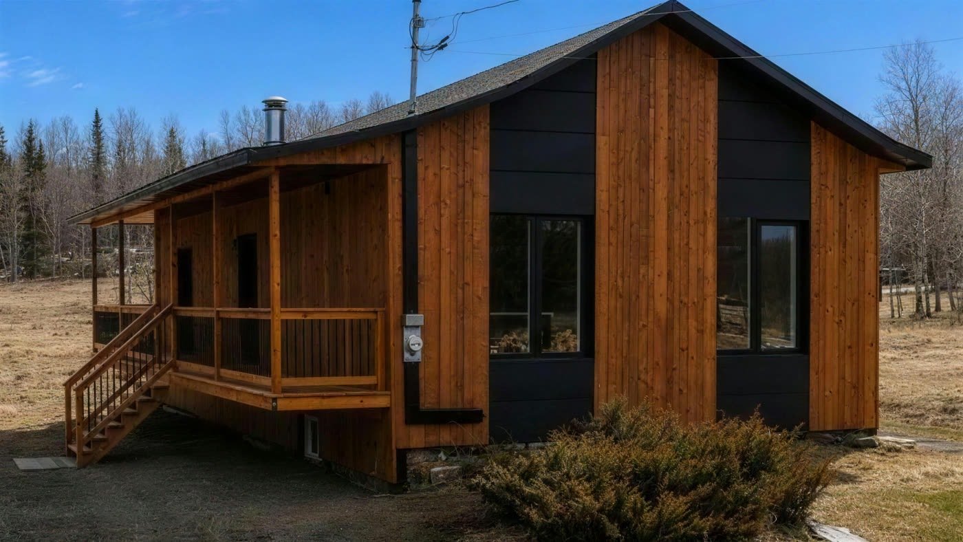 La maison après les travaux, revêtement de bois et de noir avec une nouvelle galerie