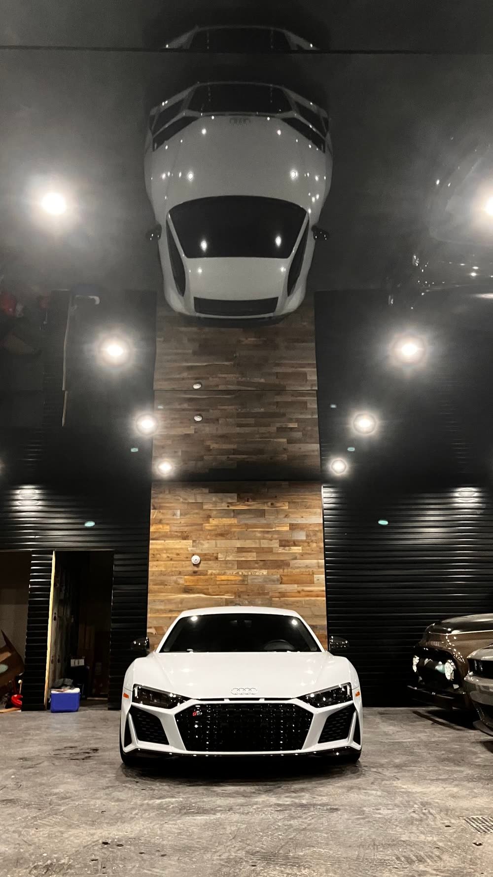 Garage avec un plafond tendu noir lustré qui reflète entièrement la voiture stationnée dessous